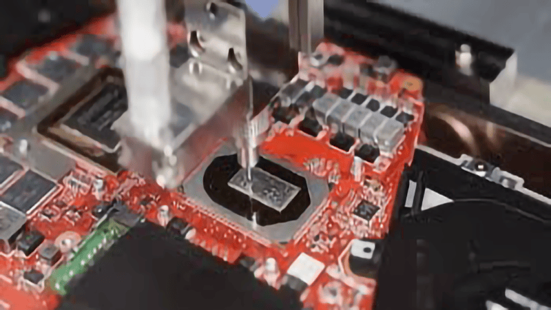 Máquina de fabricación automatizada que coloca un microchip en una placa de circuito roja
