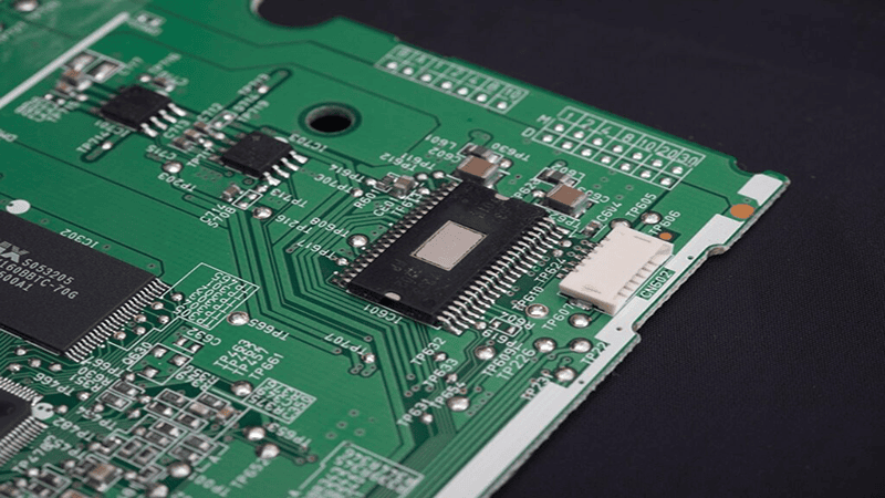 Hard drive PCB board with microchips and connectors (green circuit board, component close-up)