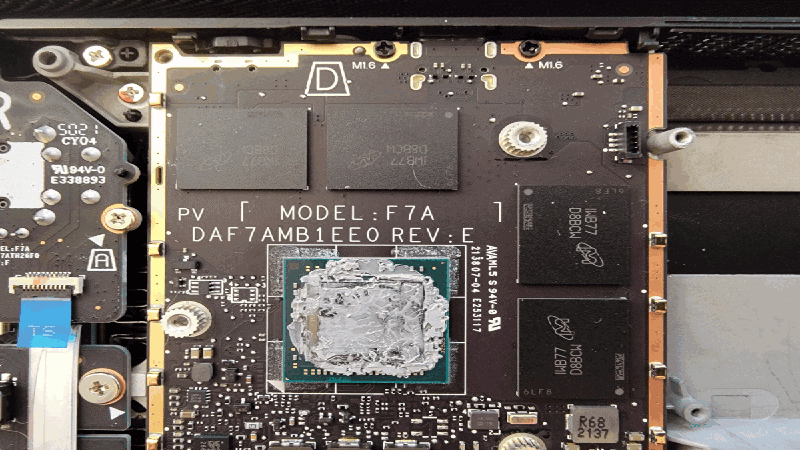 Close-up view of a CPU/GPU die on a circuit board with applied PTM7950 phase change material after use, showing the melted, semi-liquid state that ensures excellent surface contact for thermal transfer.