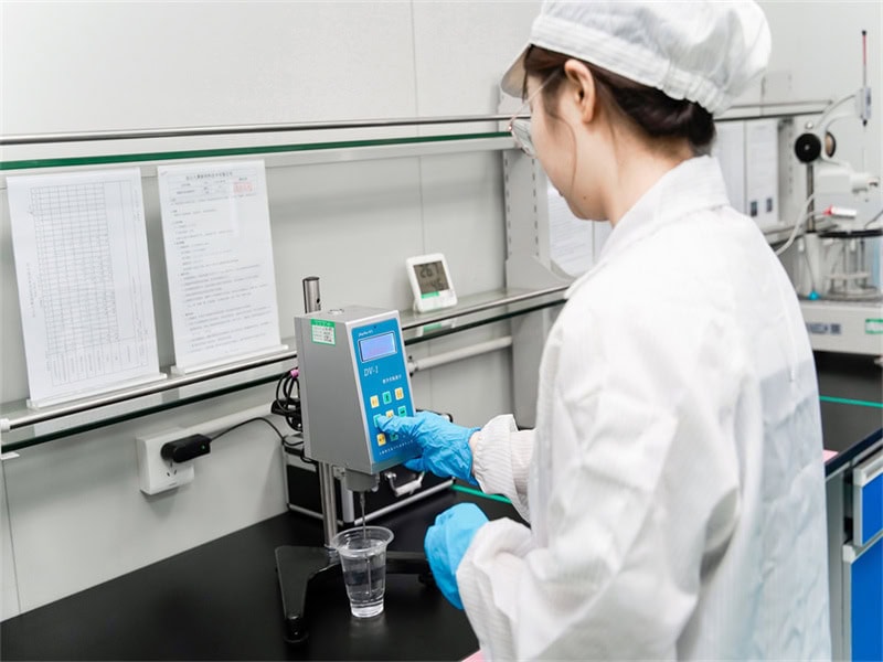 Un investigador del departamento de I+D de Jiuju está probando la viscosidad de un material con un viscosímetro digital.