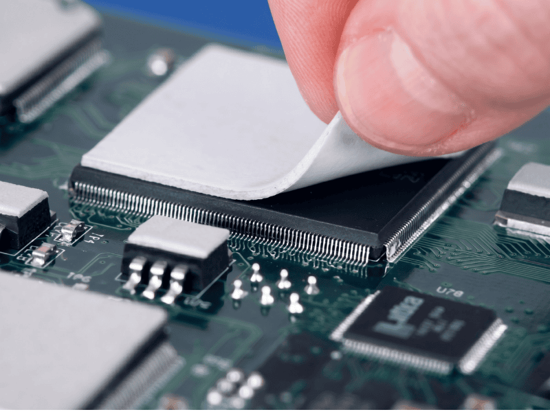 Almohadilla de material de interfaz térmica Jiuju en un microchip de PCB.