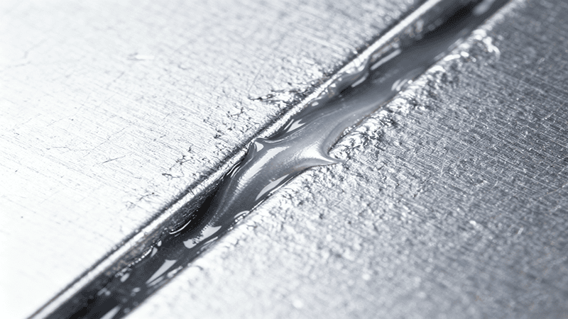  A technician in a lab coat and gloves touching a glowing, transparent model of a battery pack, highlighting its internal heat sink and cooling system.